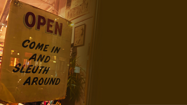 The welcome sign of The Mysterious Bookshop in New York that reads: Open - Come in and sleuth around